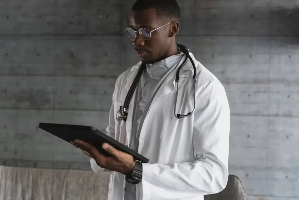 Medical professional in a white coat reviewing clinical training content on a digital tablet